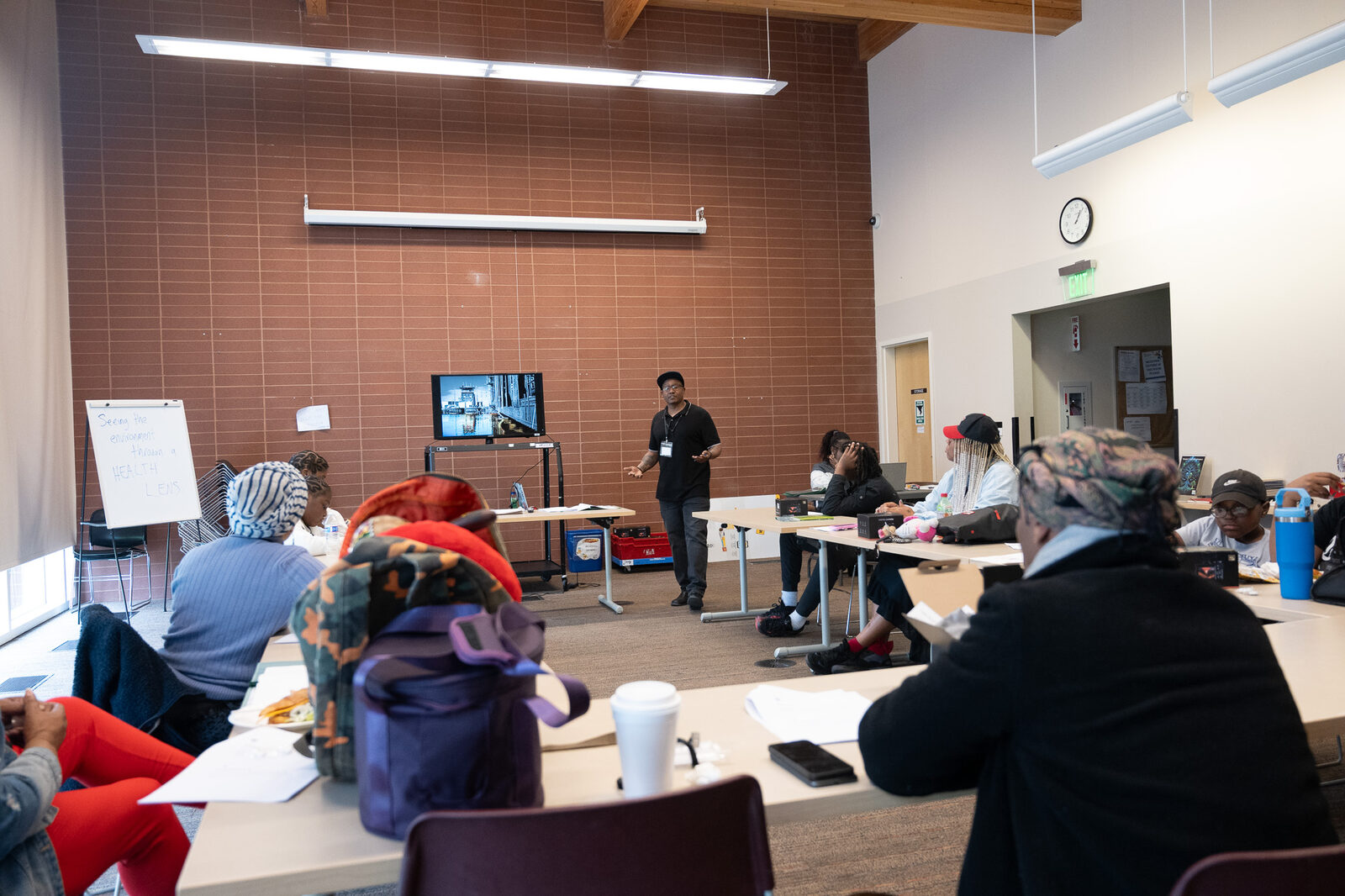 A teaching artist leads a workshop session in front of a seated group
